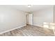 Bedroom featuring wood-look flooring, neutral walls, and entry door at 3938 N Grand Ave, Indianapolis, IN 46226