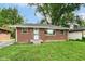 Charming brick single-story home with a well-manicured lawn and a secure front door at 3938 N Grand Ave, Indianapolis, IN 46226
