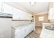 Galley kitchen featuring granite countertops, white cabinetry and stainless sink at 3938 N Grand Ave, Indianapolis, IN 46226