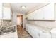 Galley kitchen featuring granite countertops, white cabinetry and stainless sink at 3938 N Grand Ave, Indianapolis, IN 46226