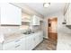 Updated kitchen with white cabinets, granite countertops, and wood-look floors at 3938 N Grand Ave, Indianapolis, IN 46226