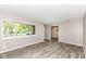 Well-lit living room featuring neutral walls, wood-look flooring, and a large window at 3938 N Grand Ave, Indianapolis, IN 46226