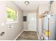 Utility room featuring wood-look flooring, neutral walls, and water heater at 3938 N Grand Ave, Indianapolis, IN 46226