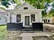 Charming white home featuring a covered front porch with painted brick and updated entry door at 405 N Bradley Ave, Indianapolis, IN 46201