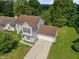 Aerial view of a charming home surrounded by lush trees and manicured lawns on a bright, sunny day at 4533 Golden Meadow Dr, Indianapolis, IN 46254