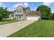 Two-story home with an attached garage, a well-manicured lawn, and a long driveway under a sunny sky at 4533 Golden Meadow Dr, Indianapolis, IN 46254