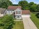 Aerial view of a two-story home with an attached garage, surrounded by lush greenery and blue skies at 4533 Golden Meadow Dr, Indianapolis, IN 46254