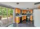 Bright kitchen with wood cabinets, black appliances, and sliding glass doors to a backyard deck at 4533 Golden Meadow Dr, Indianapolis, IN 46254