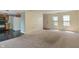 Open living space with neutral walls, a view to the kitchen, and sliding glass doors bringing in natural light at 4533 Golden Meadow Dr, Indianapolis, IN 46254