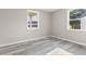 Neutral bedroom with gray walls and new floors, and natural light from the two bright windows at 4749 W Smith Valley Rd, Greenwood, IN 46142