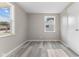 Bright bedroom featuring gray walls, durable wood-look floors, and two bright windows at 4749 W Smith Valley Rd, Greenwood, IN 46142
