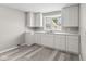 Modern kitchen with white cabinets, gray walls, a large window, and vinyl floors at 4749 W Smith Valley Rd, Greenwood, IN 46142