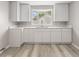 Bright and modern kitchen featuring white cabinets, gray walls, and vinyl floors at 4749 W Smith Valley Rd, Greenwood, IN 46142