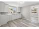 This is a modern kitchen with sleek white cabinetry, quartz countertops, and gray vinyl floors at 4749 W Smith Valley Rd, Greenwood, IN 46142