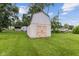 White storage shed with light brown double doors nestled in green backyard at 4749 W Smith Valley Rd, Greenwood, IN 46142