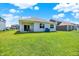 Expansive backyard with a covered patio, lush green lawn, and neighboring homes at 5120 Woodhurst Ln, Indianapolis, IN 46239