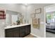 Bathroom with double sinks, dark wood cabinets, a large mirror, and decorative art at 5120 Woodhurst Ln, Indianapolis, IN 46239