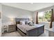 This bedroom features a large window, a bed with decorative pillows, and matching end tables with lamps at 5120 Woodhurst Ln, Indianapolis, IN 46239