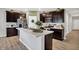 Modern kitchen featuring dark cabinetry, stainless steel appliances, and a center island with a sink at 5120 Woodhurst Ln, Indianapolis, IN 46239