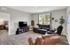 Comfortable living room features a leather sofa, chair, tv and natural light at 5120 Woodhurst Ln, Indianapolis, IN 46239