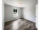 Neutral bedroom featuring wood-look floors, a window overlooking the street, and fresh paint at 5210 Sandy Forge Dr, Indianapolis, IN 46221