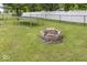 This backyard features a trampoline, a firepit, and a white fence lining the perimeter at 5504 Grassy Bank Dr, Indianapolis, IN 46237