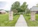 Landscaped community entrance with brick columns and a sidewalk leading to amenities at 5504 Grassy Bank Dr, Indianapolis, IN 46237