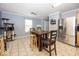 Kitchen with tile floors, stainless steel refrigerator, wooden table with chairs, and a cat play structure at 5504 Grassy Bank Dr, Indianapolis, IN 46237