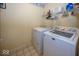 This laundry room features a washer, a dryer, storage shelves, and linoleum flooring at 5504 Grassy Bank Dr, Indianapolis, IN 46237