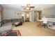 Large living room featuring neutral carpet, a ceiling fan, and multiple seating areas at 5504 Grassy Bank Dr, Indianapolis, IN 46237
