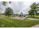 Community playground with swings, slides, and benches surrounded by lush greenery at 5504 Grassy Bank Dr, Indianapolis, IN 46237
