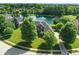 A beautiful brick home is seen from an aerial view, backing up to a pond with a fountain at 5761 Coopers Hawk Dr, Carmel, IN 46033