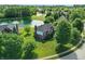 A beautiful brick home is seen from an aerial view, backing up to a pond with a fountain and mature landscaping at 5761 Coopers Hawk Dr, Carmel, IN 46033