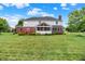 Expansive backyard view showcasing a well-maintained lawn, screened-in porch, and brick facade at 5761 Coopers Hawk Dr, Carmel, IN 46033
