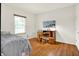 Bedroom with wooden floors, work desk, and window with wood trim and venetian blinds at 5761 Coopers Hawk Dr, Carmel, IN 46033