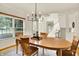 Bright dining room with wood table, modern chandelier, and large window bringing the outside in at 5761 Coopers Hawk Dr, Carmel, IN 46033