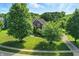 Traditional brick home with mature trees and landscaping in the front yard at 5761 Coopers Hawk Dr, Carmel, IN 46033