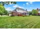 Spacious backyard with manicured lawn and mature trees, creating a serene outdoor space at 5761 Coopers Hawk Dr, Carmel, IN 46033