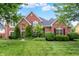 Stunning two-story brick home featuring a manicured lawn and mature trees at 5761 Coopers Hawk Dr, Carmel, IN 46033