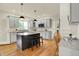 Modern kitchen featuring grey cabinets, stainless appliances, central island, and beautiful hardwood floors at 5761 Coopers Hawk Dr, Carmel, IN 46033