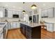 Spacious kitchen with modern appliances, a central island with granite countertop and black cabinets at 5761 Coopers Hawk Dr, Carmel, IN 46033