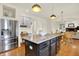 Bright open kitchen with stainless steel appliances and an island, flowing to the dining and living spaces at 5761 Coopers Hawk Dr, Carmel, IN 46033