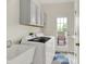 Efficient laundry room with modern washer and dryer, ample storage, and access to the outside at 5761 Coopers Hawk Dr, Carmel, IN 46033