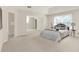 Main bedroom featuring a tray ceiling, neutral carpet, and a large seating area at 5761 Coopers Hawk Dr, Carmel, IN 46033