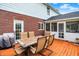 Charming patio with a dining table and chairs, adjacent to a screened porch and a well-maintained brick facade at 5761 Coopers Hawk Dr, Carmel, IN 46033