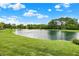 Beautiful pond view with fountain and green lawn under a sunny, partly cloudy sky at 5761 Coopers Hawk Dr, Carmel, IN 46033