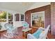Screened-in porch has wicker furniture and a view of the kitchen through a doorway at 5761 Coopers Hawk Dr, Carmel, IN 46033