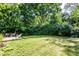 Expansive backyard with mature trees, a wooden deck, and ample space for outdoor activities at 6491 N Oxford St, Indianapolis, IN 46220