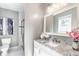Bathroom with a marble countertop vanity, updated mirror, shower with glass door, and new fixtures at 6491 N Oxford St, Indianapolis, IN 46220