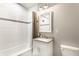 Bathroom with a grey countertop vanity, updated mirror, shower/tub and new fixtures at 6491 N Oxford St, Indianapolis, IN 46220